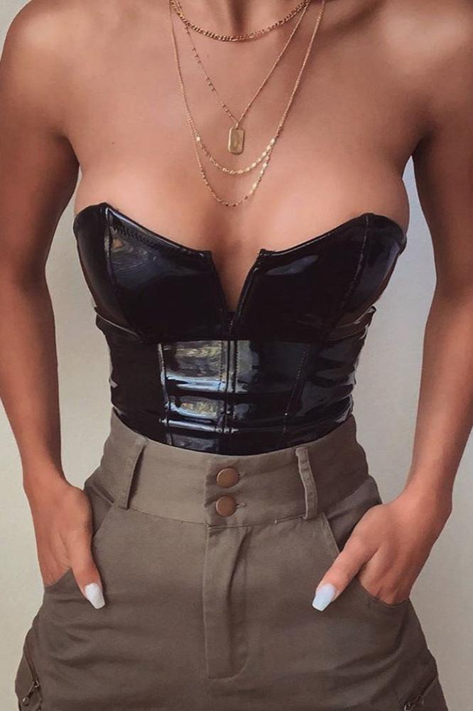 Model wearing black leather corset bodysuit paired with high-waisted pants